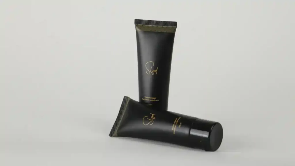 Hand applying vaginal lubricants to a silicone dildo for safe use